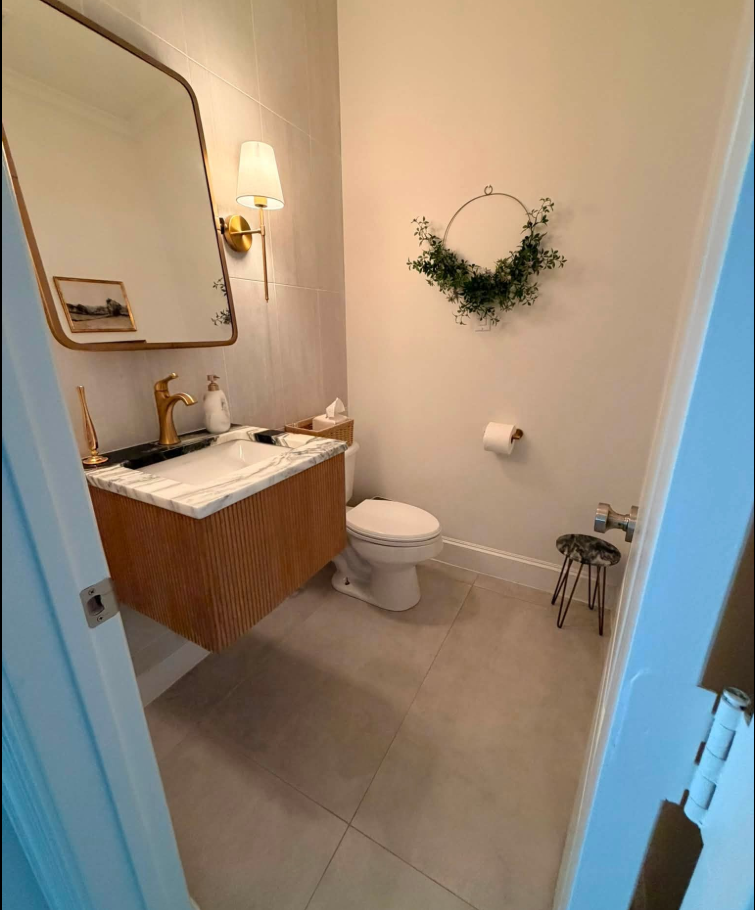 Immaculate powder room with polished marble vanity and mirror